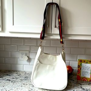 White shoulder bag with bumble bee strap.